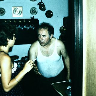 Shirtless man and woman in vintage indoor setting.
