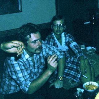 Group of people gathered indoors, playing video game.