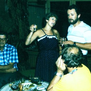 People celebrating indoors with drinks and laughter.