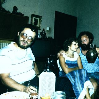Four people gathered indoors, posing together.