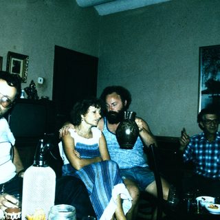 Four people gathered indoors, posing together.