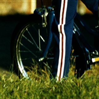 Three children playing with bicycles outdoors.