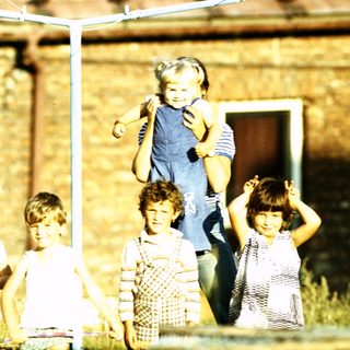 Five children playing under a swing set.