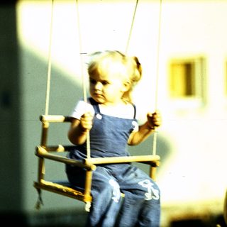 Child swinging on a swing outdoors.
