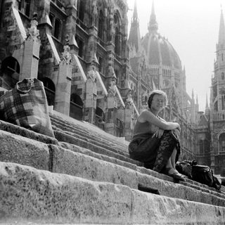 Woman sitting on cathedral steps in Gothic architecture.