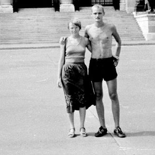 Two people posing in front of grand historic building.