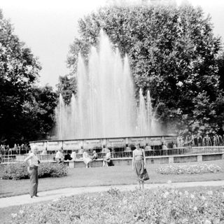 Large fountain in park with people around.