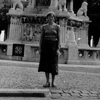Historic fountain plaza with ornate architecture and people.