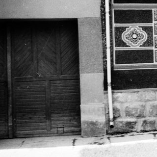 Vintage street scene with traditional building and three people.