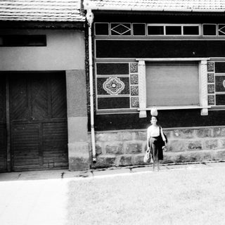 Vintage street scene with traditional building and three people.