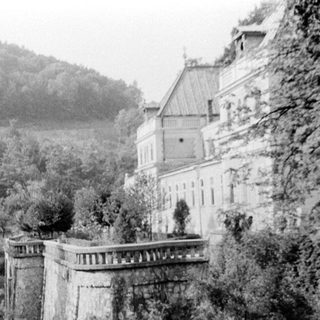 Historic building entrance with stone wall and pathway.