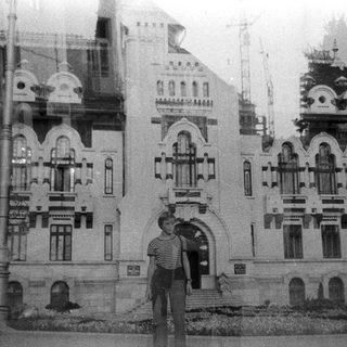 Historic building with ornate architecture, two people posing outside.