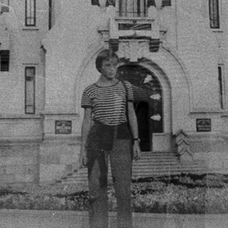 Historic building with ornate architecture, two people posing outside.