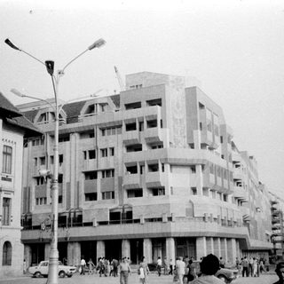 Urban street scene with mid-century buildings under construction.