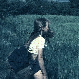 Two people hiking through tall grass.