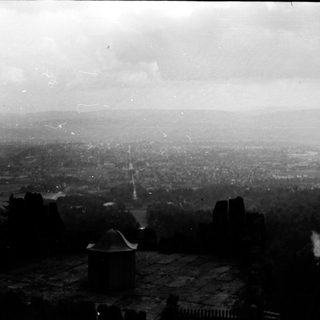 Panoramic view of a city from elevated vantage point.