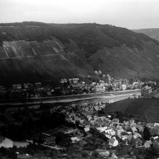 Aerial view of rural village nestled in hilly countryside.