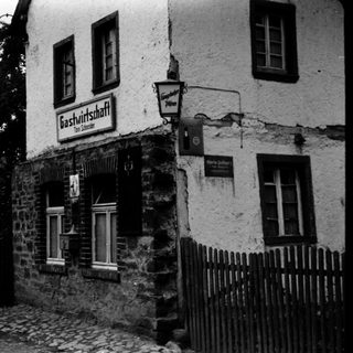 Rustic black-and-white photo of a traditional German inn.