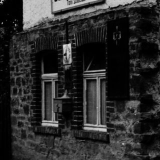 Rustic black-and-white photo of a traditional German inn.
