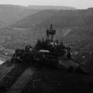 Historic town perched on hillside by river.