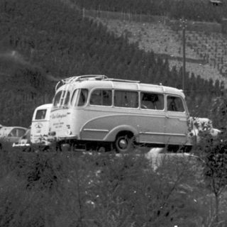 Historic inn with vintage bus and cars.