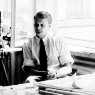 Two people working at desks in a bright office.