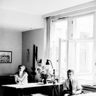 Two people working at desks in a bright office.