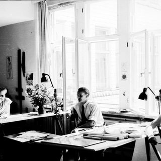 Three people working collaboratively in a bright studio.