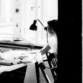 Three people working collaboratively in a bright studio.