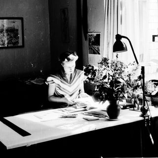 Woman studying or working at a desk with papers.