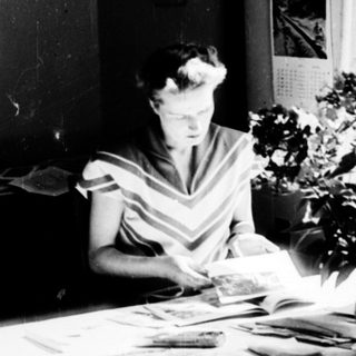 Woman studying or working at a desk with papers.