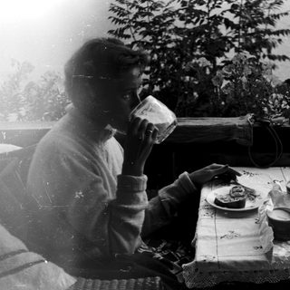Person drinking tea at a table with food.