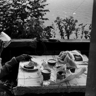 Person drinking tea at a table with food.
