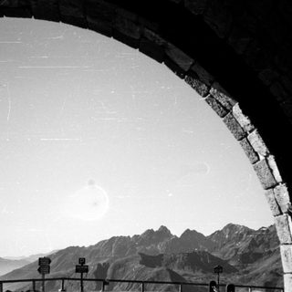 Architectural arch framing mountain landscape.