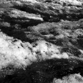 Rough, textured lunar surface with craters.