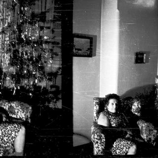 Two women sitting on patterned furniture indoors.