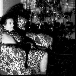 Two women sitting on patterned furniture indoors.