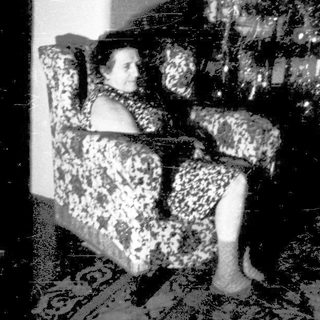 A person sitting alone on a couch in a dimly lit room.