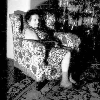 A person sitting alone on a couch in a dimly lit room.