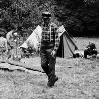 Campsite with tents and people outdoors.