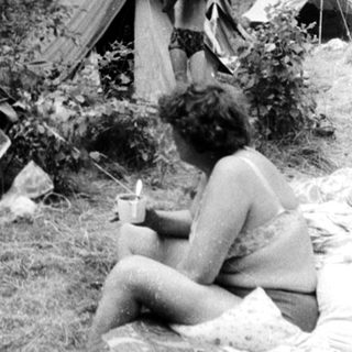 Campsite with tents and people outdoors.