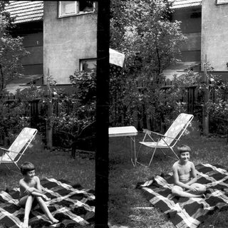 Two children lounging on makeshift sunbathing platforms.