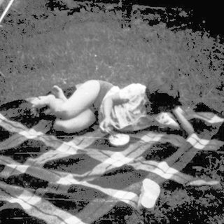 Blurred nighttime courtyard with person lying on blanket.