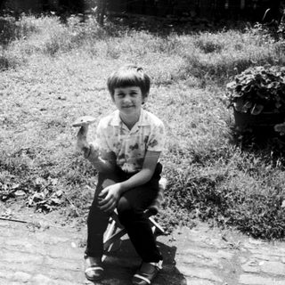 Two children sitting outdoors in backyard.