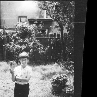 Young boy holding small bird outdoors.