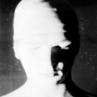 Blurred close-up of a bald person's face.