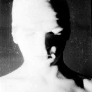 Blurred close-up of a bald person's face.
