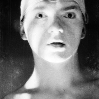 Young person wearing swim cap, blurred background.