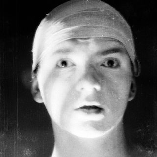 Young person wearing swim cap, blurred background.