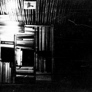 Dark room filled with tall bookshelves.